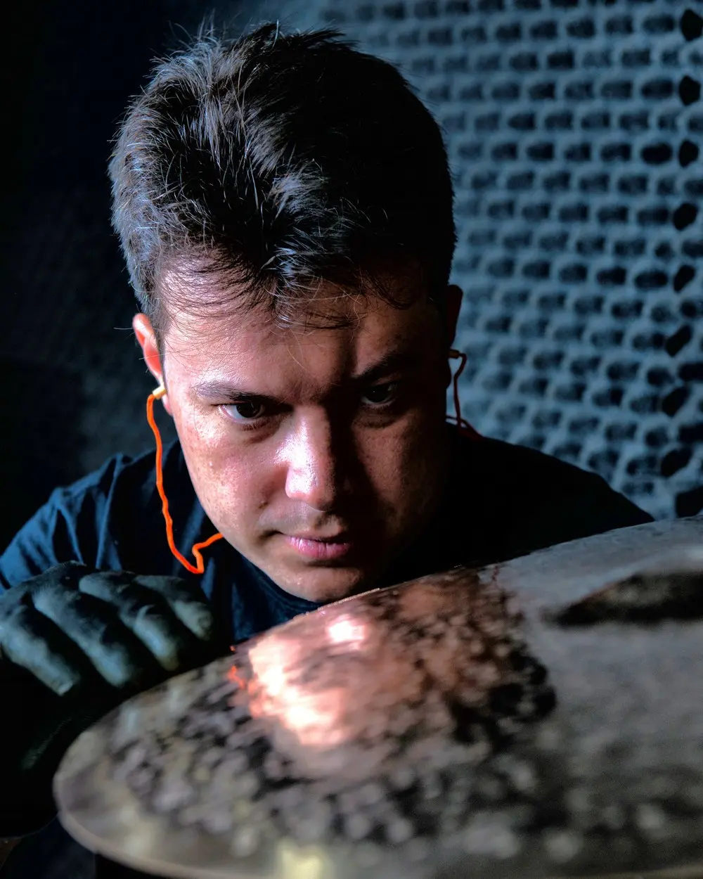 Bruno Schell, fabricante de pratos musicais Bruno Schell observando um prato musical em sua oficina.